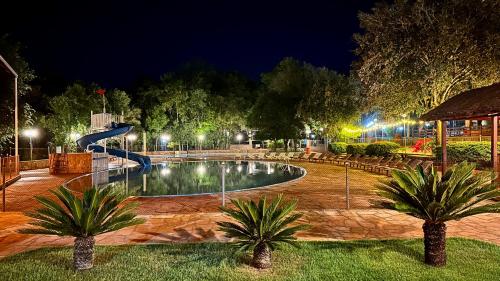a swimming pool in a park at night at Parque Hotel Manantial in Hohenau
