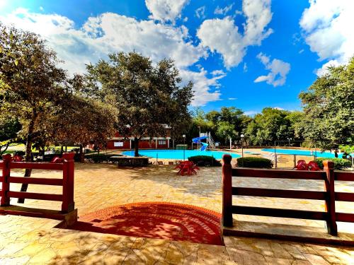 a park with a swimming pool and two fences at Parque Hotel Manantial in Hohenau