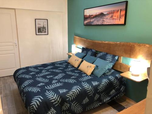 une chambre avec un lit avec une couette bleue dans l'établissement L'appart d'Antoine, à Saint-Quentin