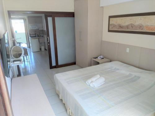 a bedroom with a bed with two towels on it at Flat a beira mar, vista lateral - Araça 408 in Natal