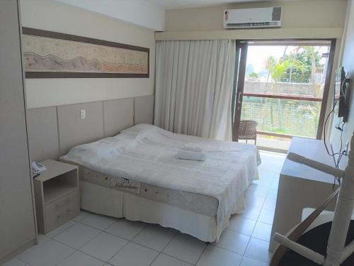 a small bedroom with a bed and a window at Flat a beira mar, vista lateral - Araça 408 in Natal