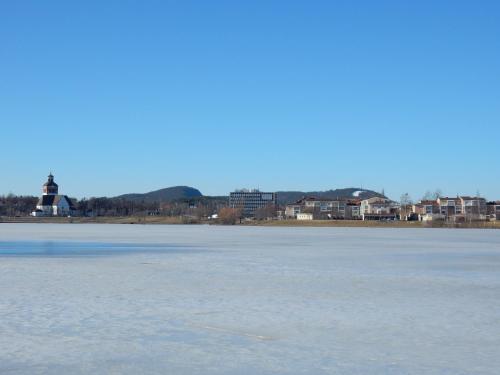a frozen lake with a lighthouse in the background at Grand Hotell Bollnäs in Bollnäs