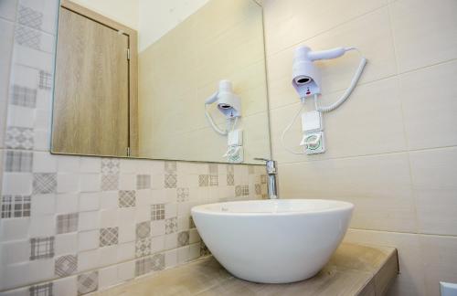 a bathroom with a white sink and a mirror at tzogias apartments nonna studio in Lassi