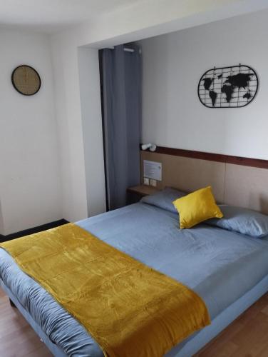 a bedroom with a bed with a yellow blanket on it at L'Albatros in Perros-Guirec