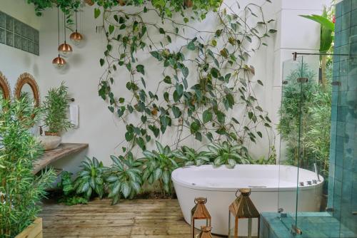łazienka z roślinami na ścianie i wanną w obiekcie El Bosque Hotel Boutique w mieście Doradal