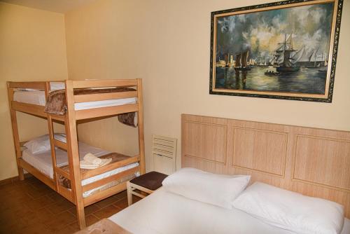 a bedroom with two bunk beds and a painting on the wall at White Sea View Apartment Velipoje in Velipojë