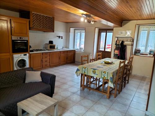 sala de estar con mesa y cocina en Gîte le grand bois, en Feins-en-Gâtinais