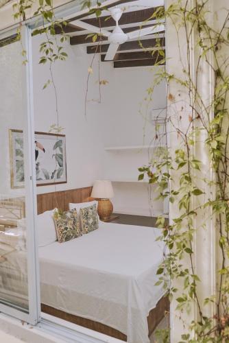 a white bed in a room with plants at El Bosque Hotel Boutique in Doradal