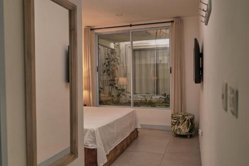 a bedroom with a bed and a large window at El Bosque Hotel Boutique in Doradal