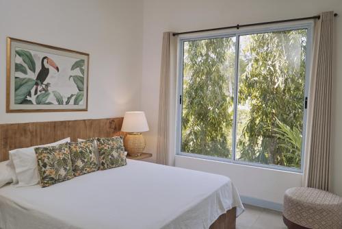 a bedroom with a bed and a large window at El Bosque Hotel Boutique in Doradal