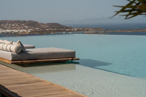 a pool with two pillows on the edge of a table at Mythic Paros , Adults Only in Agia Irini Paros