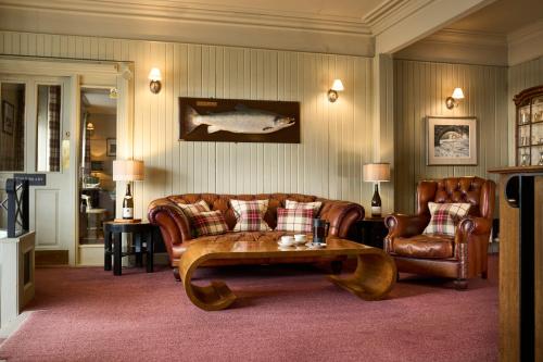 a living room with a couch and a table and chairs at Ulbster Arms Hotel near Thurso in Halkirk