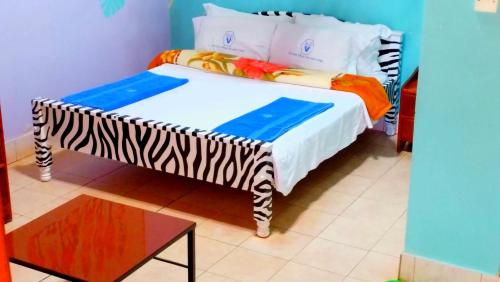a bed in a room with a zebra print sheets at Miryams Village Inn Safari Lodge in Sultan Hamud