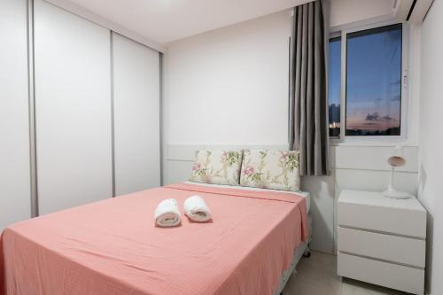 Un dormitorio con una cama rosa con zapatos blancos. en Excelente Casa de Temporada em Porto de Galinhas casa 3 en Porto de Galinhas