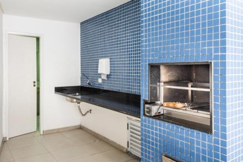 a kitchen with a blue tiled wall with a oven at Excelente Casa de Temporada em Porto de Galinhas casa 3 in Porto De Galinhas