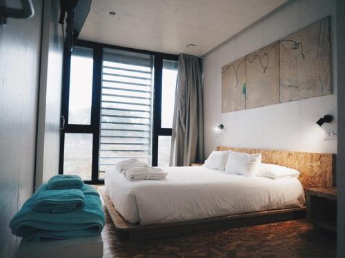 1 dormitorio con cama y ventana grande en Mardesía, en Sanxenxo