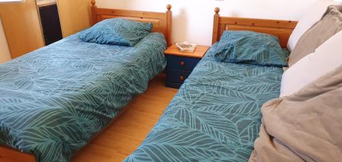 deux lits côte à côte dans une chambre dans l'établissement STUDIO A LOUER, à Lamalou-les-Bains