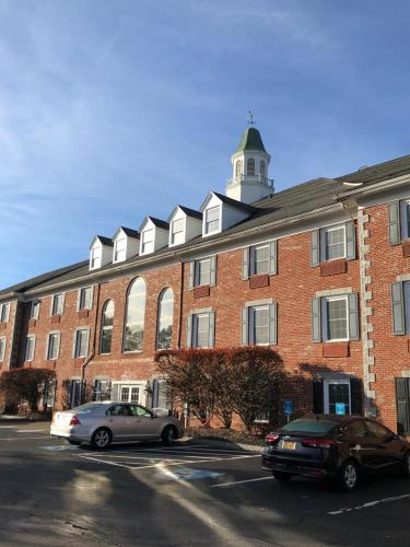 a large red brick building with a clock tower at Comfort Inn Rockland - Boston in Rockland
