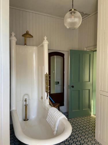 bañera grande en una habitación con puerta verde en Ashville Georgian House, en Killinchy