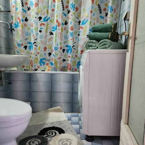 a bathroom with a toilet and a shower curtain at Shpetim's Apartment in Pristina