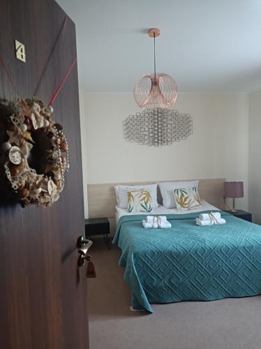 a bedroom with a bed with a blue bedspread at Villa Zdrojowa in Otmuchów