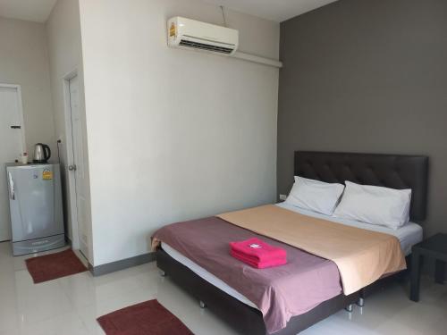 ein Schlafzimmer mit einem Bett mit einer rosa Tasche darauf in der Unterkunft Modern resort..โมเดิร์นรีสอร์ท in Thang Kwian