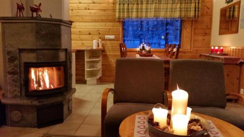a living room with a fireplace and a table with candles at Petäjäkylä in Kuusamo