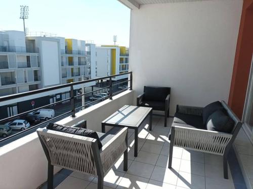 un balcon avec une table et des chaises sur un immeuble dans l'établissement Bel appartement à Royan, tout à pied., à Royan