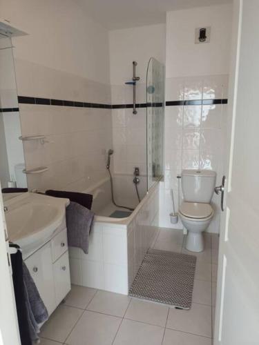 une salle de bain avec une baignoire, des toilettes et un lavabo dans l'établissement Bel appartement à Royan, tout à pied., à Royan