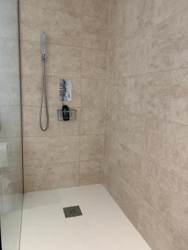 a shower with a shower head and a shower at Self contained annex with bedroom bathroom sitting room and kitchenette in Emsworth
