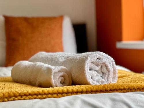 einen Stapel Handtücher auf dem Bett in der Unterkunft Daubney House - Great for Contractors or Family Holidays in Cleethorpes