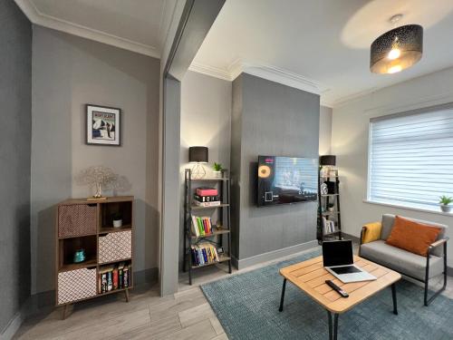 a living room with a couch and a table with a laptop at Daubney House - Great for Contractors or Family Holidays in Cleethorpes