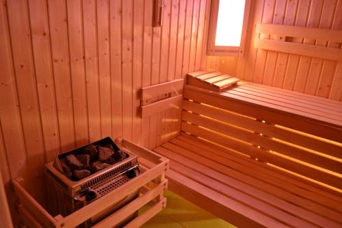 a sauna with a tub and logs in it at Hotel Granit Smrekovica in Liptovská Osada