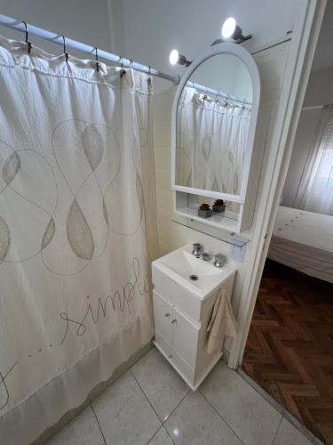 y baño con cortina de ducha y lavamanos. en De Esa HOME en Buenos Aires