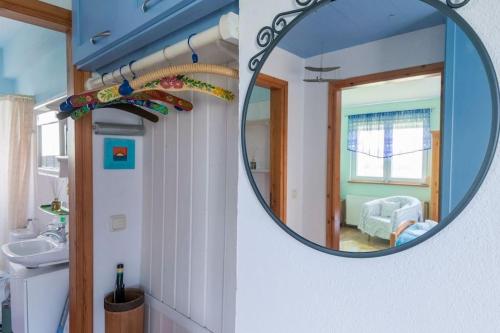 a mirror in a bathroom with a sink and a room at Big house with a huge garden and barbecue area! in Flogita