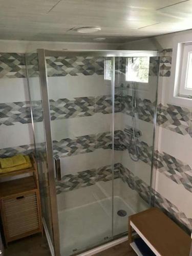 a shower with a glass door in a room at Le Sapin in Audrehem