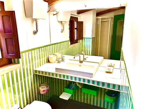 a bathroom with a sink and a mirror at Casa De Ajala - B&B de Charme in Antica Dimora totalmente ristrutturata e dotata di tutti i confort Bagni privati Spazio living Patio esterno Ambienti climatizzati Degustazioni prodotti locali in Làconi