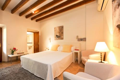 een slaapkamer met een groot wit bed en een bank bij Fornalutx Petit Hotel - Turismo de Interior in Fornalutx