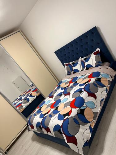- une chambre avec un lit et une couette colorée dans l'établissement Lectorului Residence 3 rooms Colosseum Mall, à Bucarest