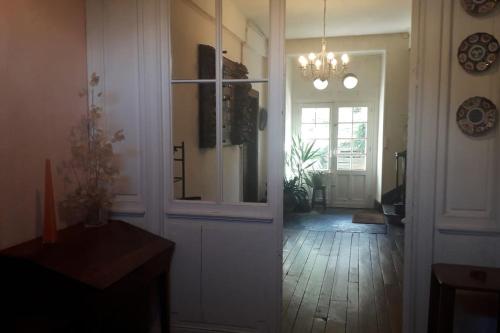 um quarto com um corredor com uma porta e um lustre em Magnifique maison de maître du 18e avec jardin em Luz-Saint-Sauveur