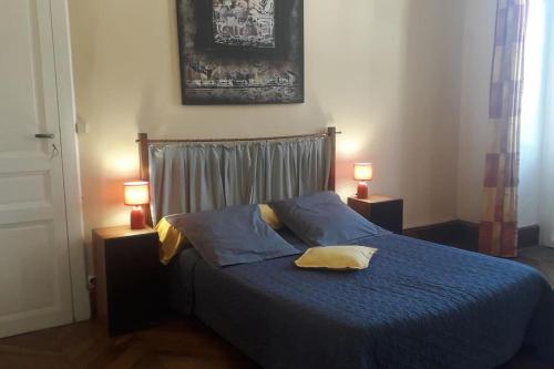 - une chambre avec un lit avec des draps bleus et deux lampes dans l'établissement Magnifique maison de maître du 18e avec jardin, à Luz-Saint-Sauveur