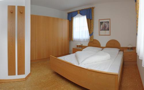 - une chambre avec un grand lit et des draps blancs dans l'établissement Mühlrast, à Laces