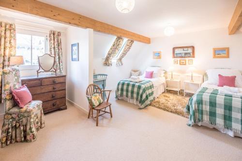 a bedroom with two beds and a chair at Church Farm House Campsea Ashe in Woodbridge