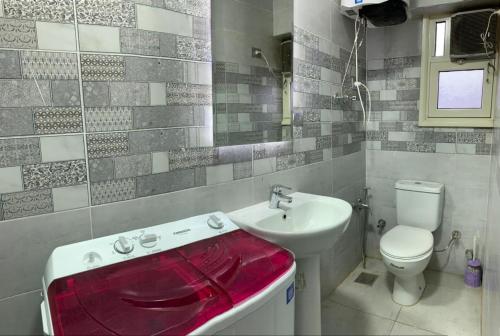 uma casa de banho com um lavatório branco e um WC. em شقة فندقية جديدة no Cairo