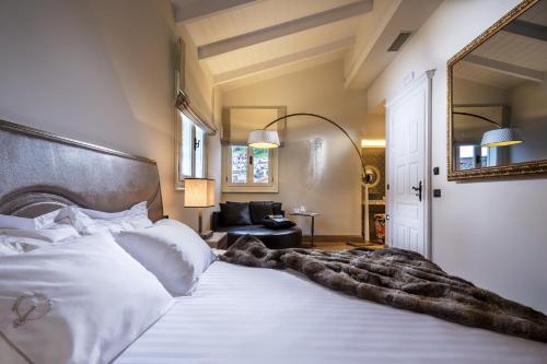a bedroom with a large white bed with a large mirror at 3 Sixty Hotel & Suites in Nafplio