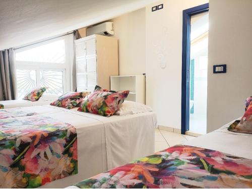 1 dormitorio con 2 camas y mesa con almohadas en Villa Maria Apartments nel Cuore di Riccione, en Riccione