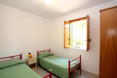 two twin beds in a room with a window at Villaggio Turistico Residence Delfino in Vieste
