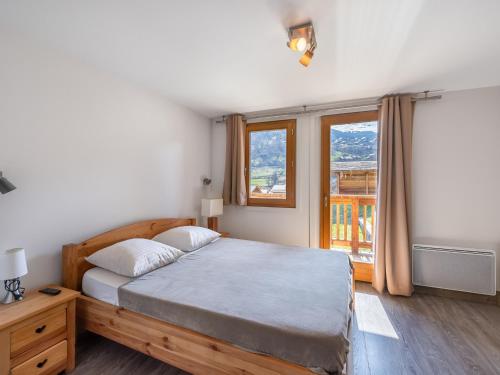une chambre avec un lit et une grande fenêtre dans l'établissement Chalet cosy au Raffort avec jardin, proche télécabines et bus, parking, animaux admis - FR-1-566-47, à Les Allues