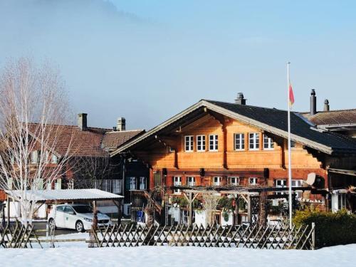 Urchige 2-Zimmerwohnung في Matten: مبنى خشبي مع علم بالثلج