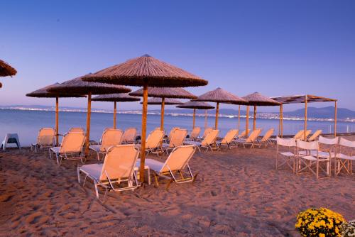 a group of chairs and umbrellas on a beach at Hotel Pithari in Agia Triada